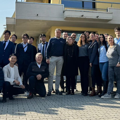 Foto di gruppo del team Dino Paoli con la delegazione giapponese fuori dalla sede dell'azienda